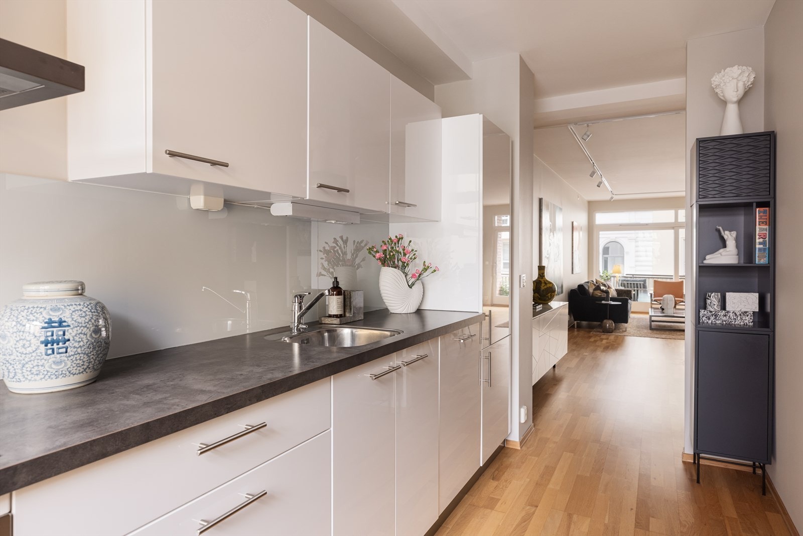 Kjøkkenet er innredet med glatte fronter og stilrene beslag, samt veggplate av glass Galleribilde