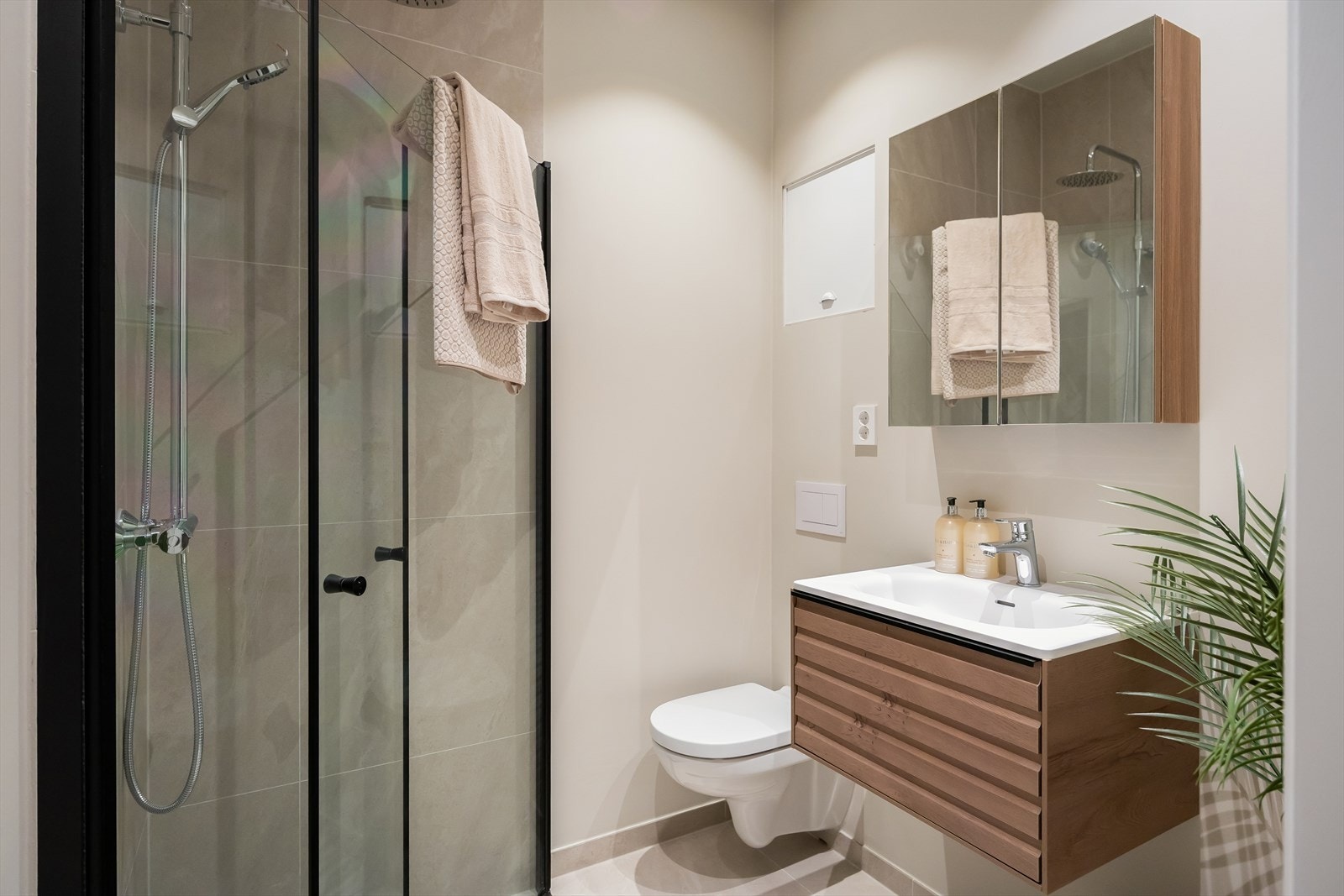 Moderne og totaloppusset flislagt bad med gulvvarme, vegghengt toalett, regnfallsdusj og innfellbare dusjdører som er plassbesparende. Galleribilde