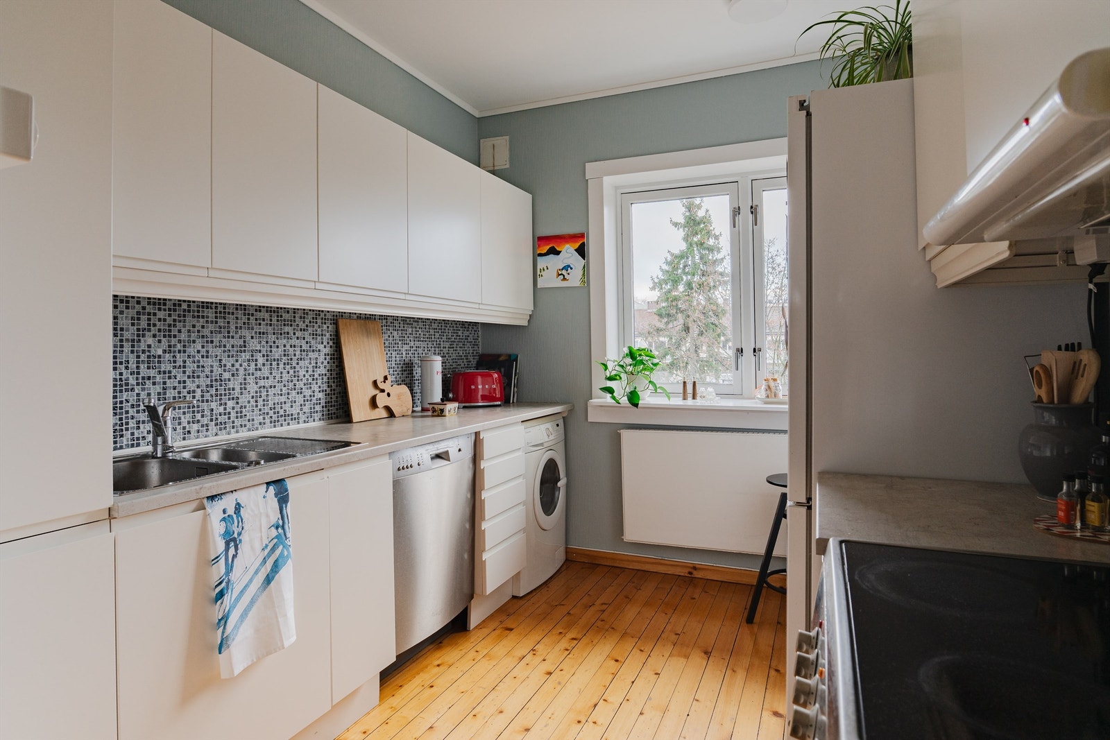 Fint og praktisk kjøkken fra 2017 i separat rom. Det er godt med benkeplass og frittstående hvitevarer som kjøl/fryseskap, oppvaskmaskin, komfyr og vaskemaskin. Galleribilde