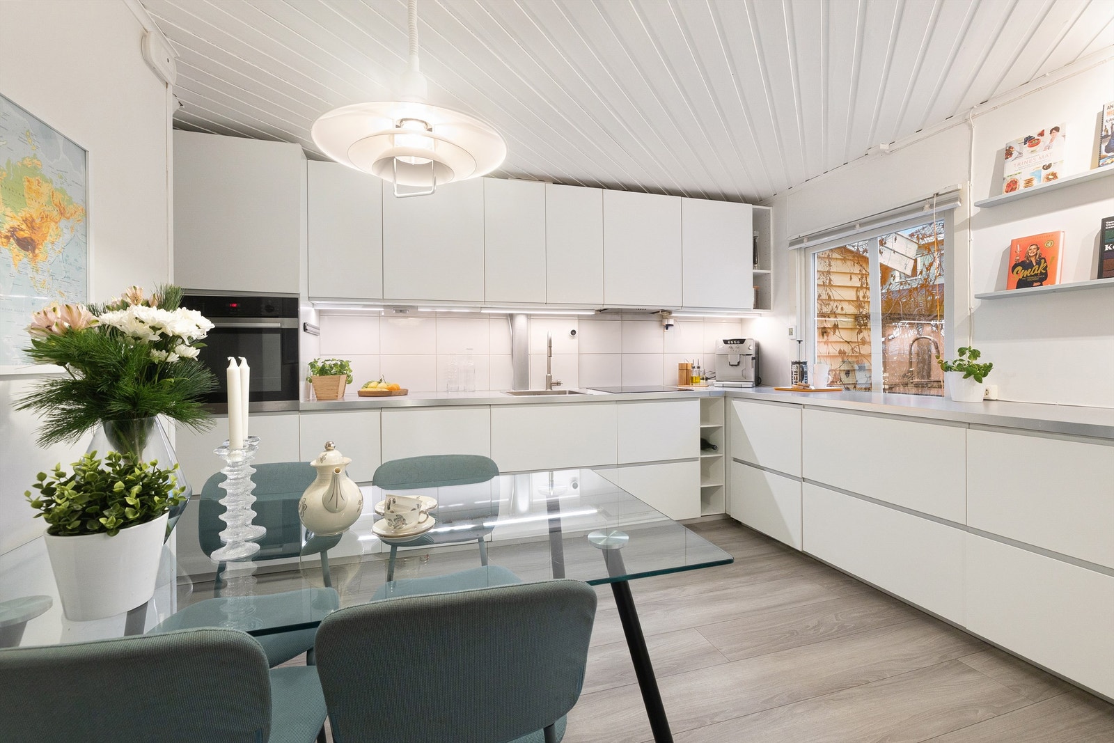 Kjøkkenet er lyst og innbydende, med rikelig skapplass og gode arbeidsflater. Det romslige kjøkkenet, fra 2013, er innredet med hvite, glatte fronter og laminat benkeplate. Galleribilde