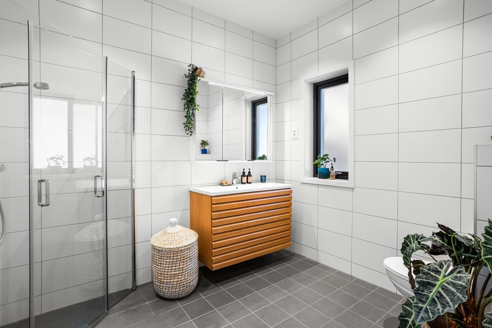 Pent bad med flislagte overflater, gulvvarme og downlights. Galleribilde