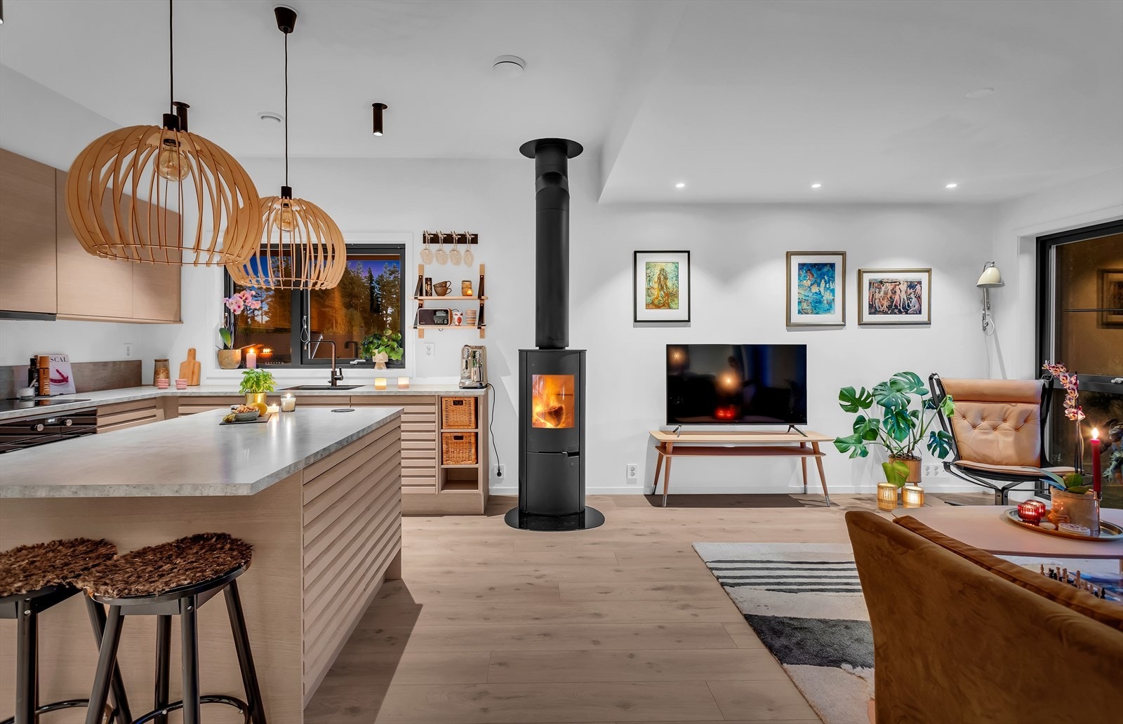 På kveldstid skaper belysningen og peisen en lun og innbydende stemning i allrommet. Galleribilde