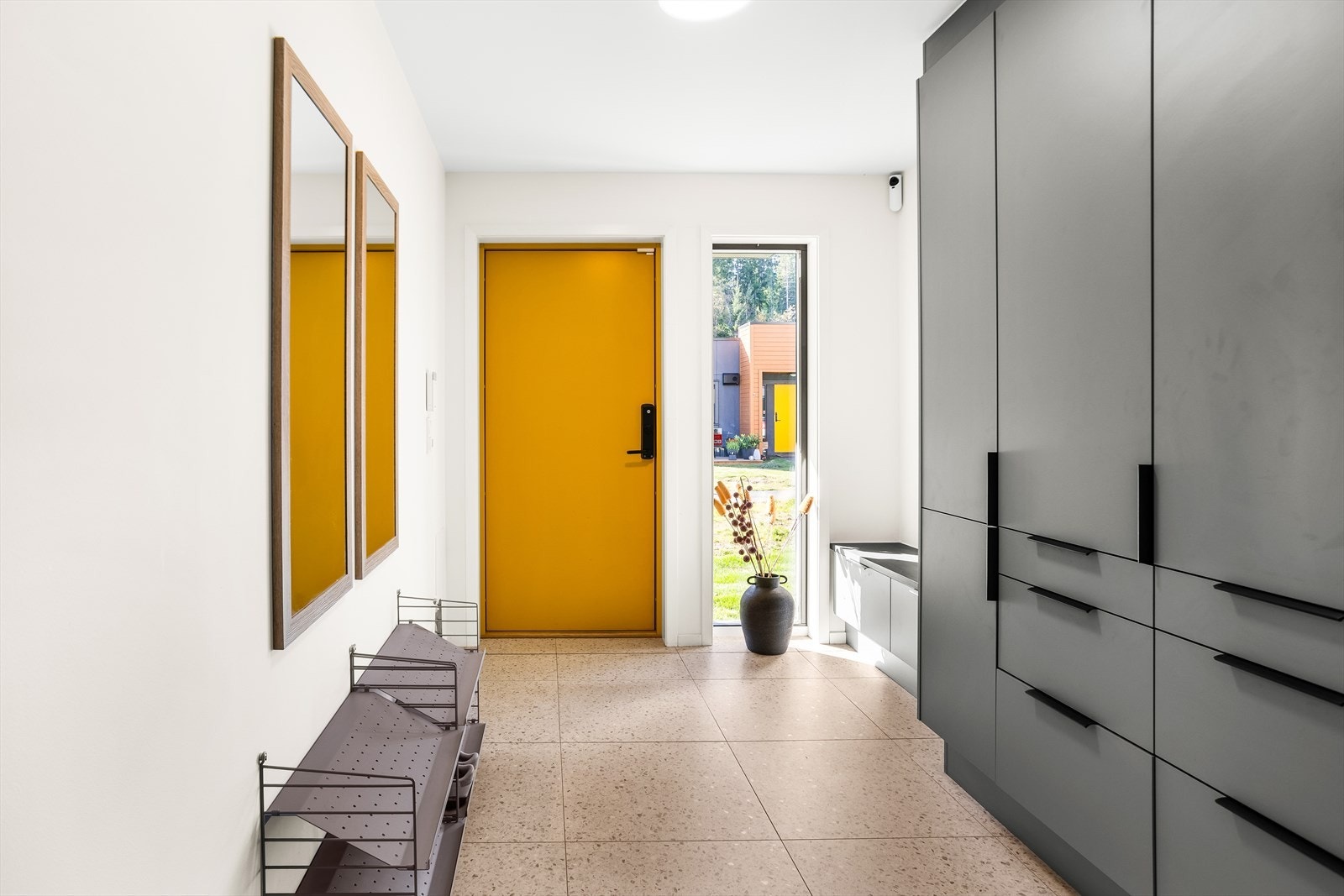 Romslig og innbydende entré med flislagt gulv som gir et godt førsteinntrykk av boligen. Garderobeskap for yttertøy og sko fra Sigdal. Galleribilde