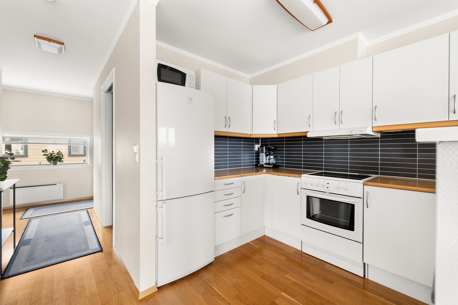 Kjøkkenet har godt med skapplass og store arbeidsflater. Kjøleskapet, komfyren og oppvaskmaskinen medfølger salget. Galleribilde