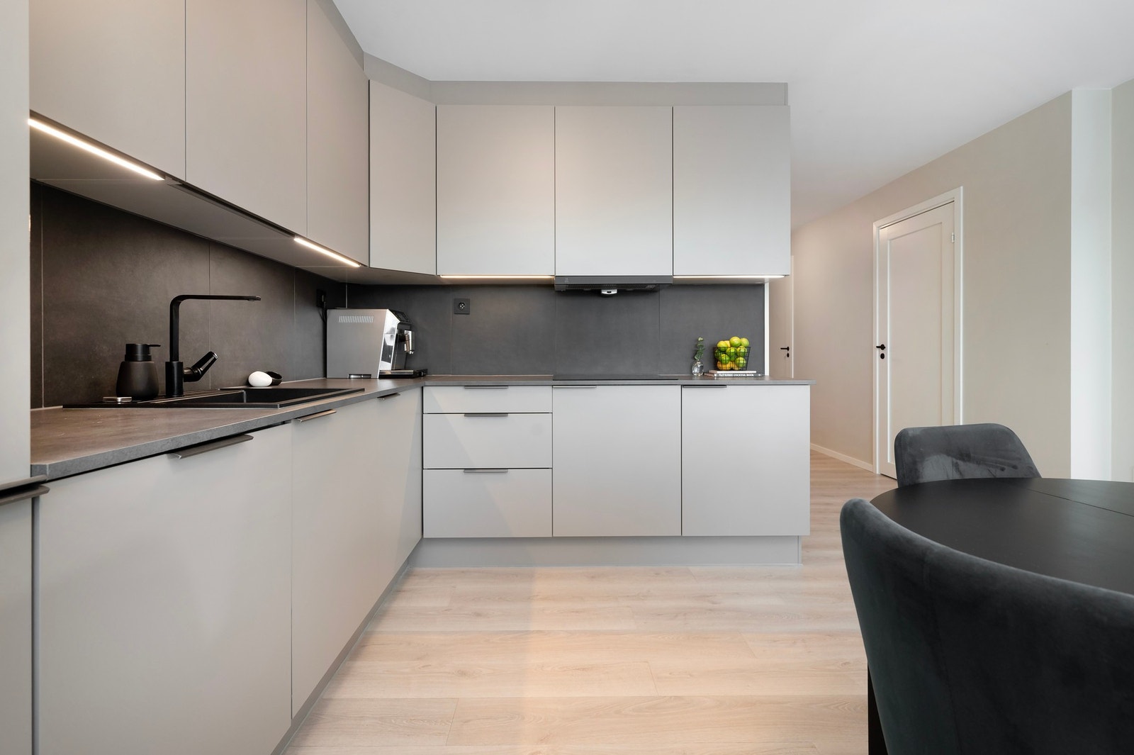 Kjøkken med glatte, grå fronter. Legg merke til overskapene som er foret til taket! Galleribilde