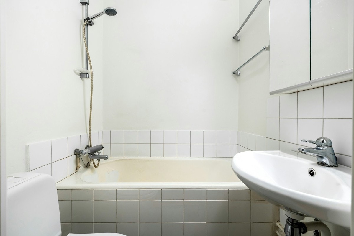 Av våtrom har leiligheten et bad med oppussingsbehov. Badet har servant, speilskap, toalett og badekar Galleribilde