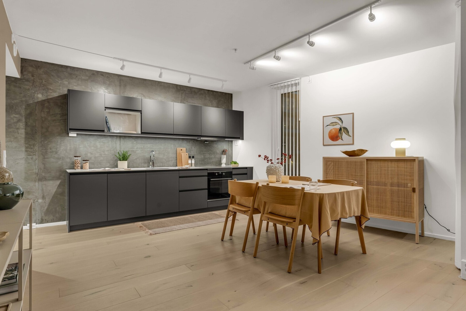 Det elegante kjøkkenet fra Drømmekjøkken er av et tidløst design med mørke fronter og en lys benkeplate av keramikk Galleribilde