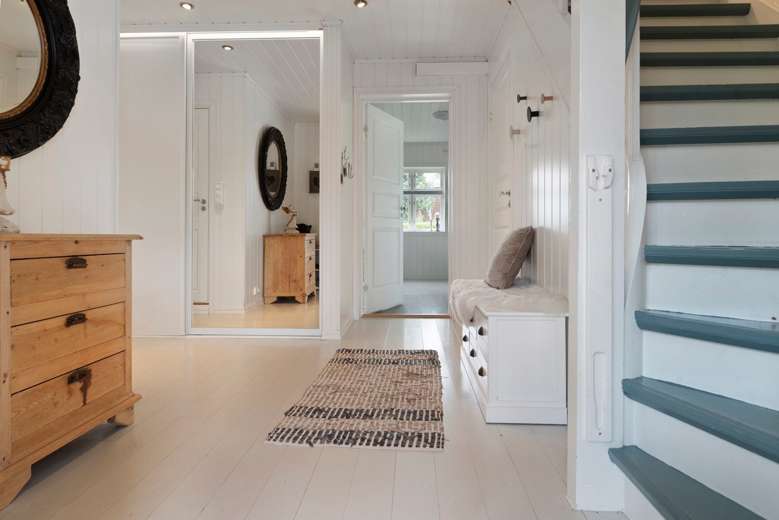 Romslig entrè/trapperom med speil skyvedørsgarderobe fra tak til gulv. Galleribilde