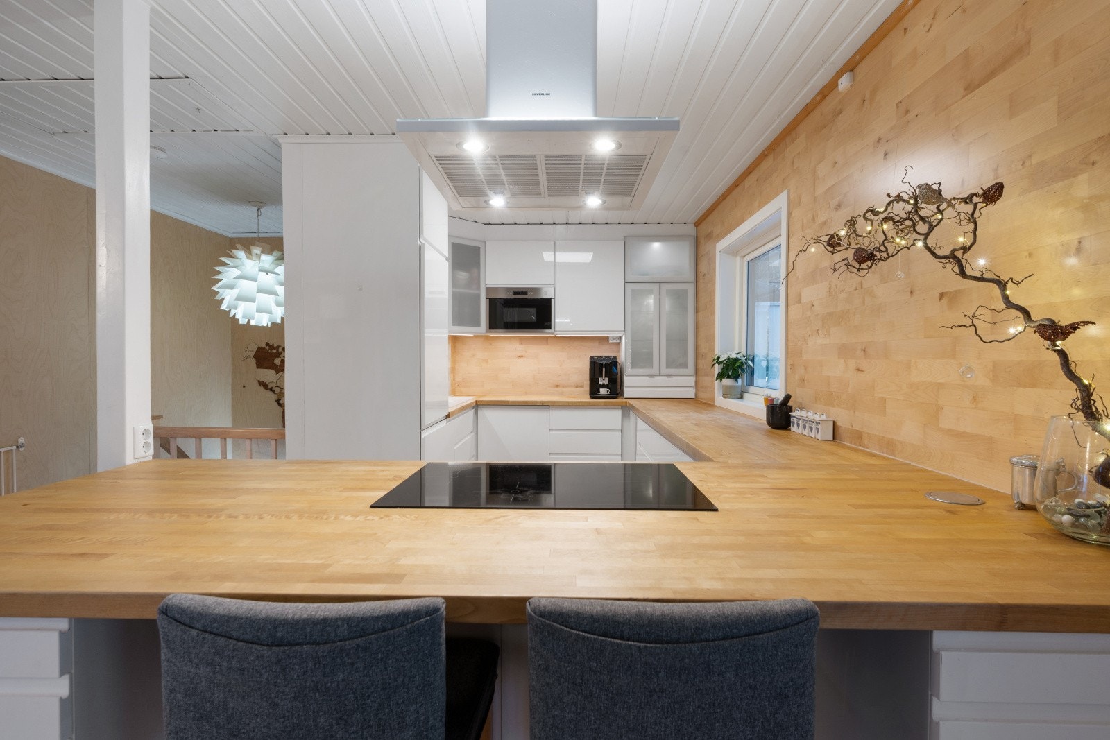 Hvite, slette fronter og heltre benkeplate gir kjøkkenet et stilrent uttrykk. Legg merke til den kreative veggen. Galleribilde