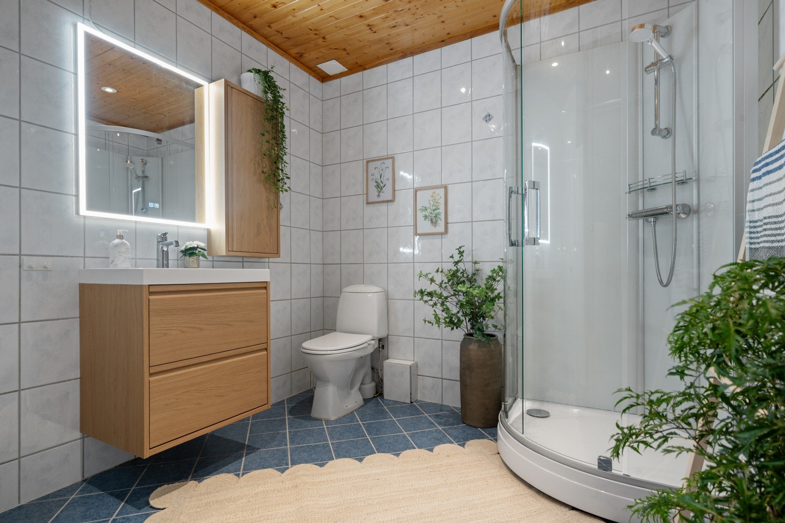 Flislagte vegger og gulv med varmekabler gir en komfortabel baderomsløsning fra 2002, innredningen er ny i 2025. Galleribilde