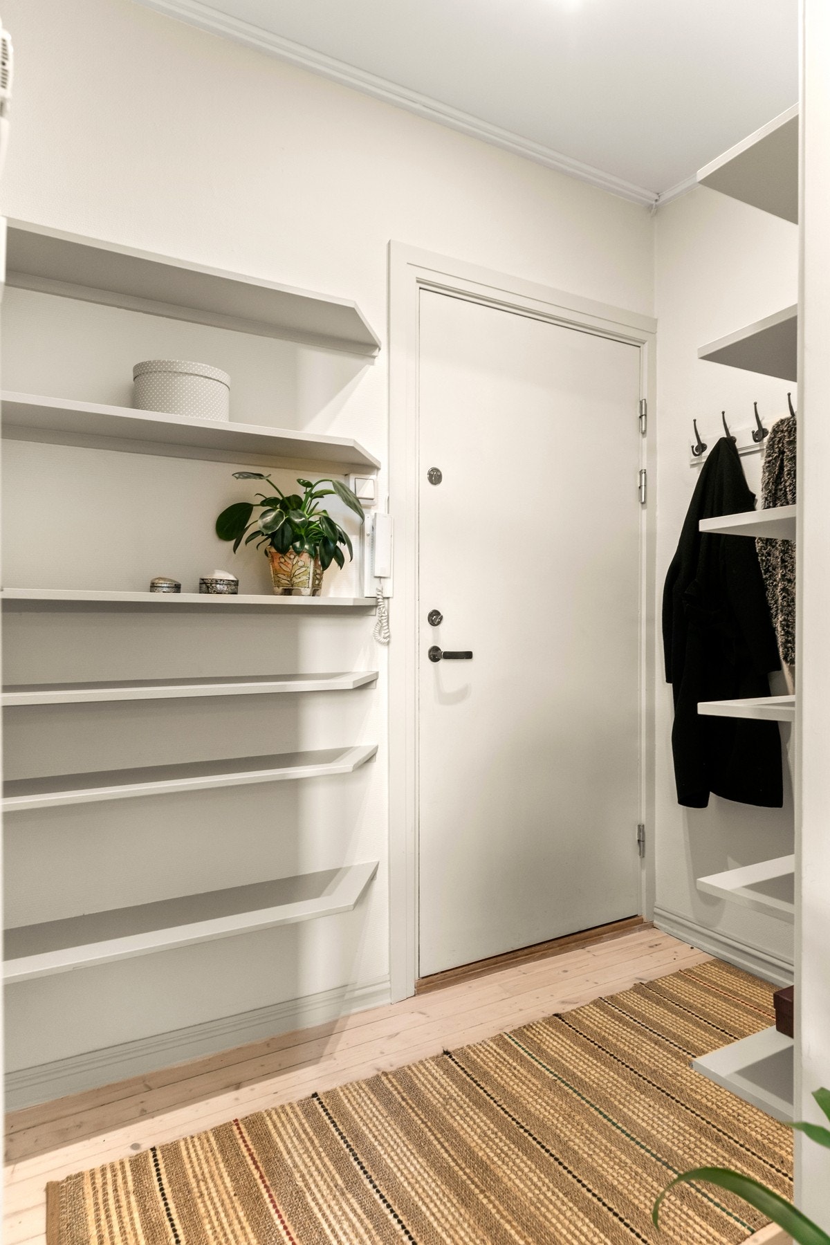 Praktiske hylleseksjoner til oppbevaring og dørcalling ved inngangsdør Galleribilde