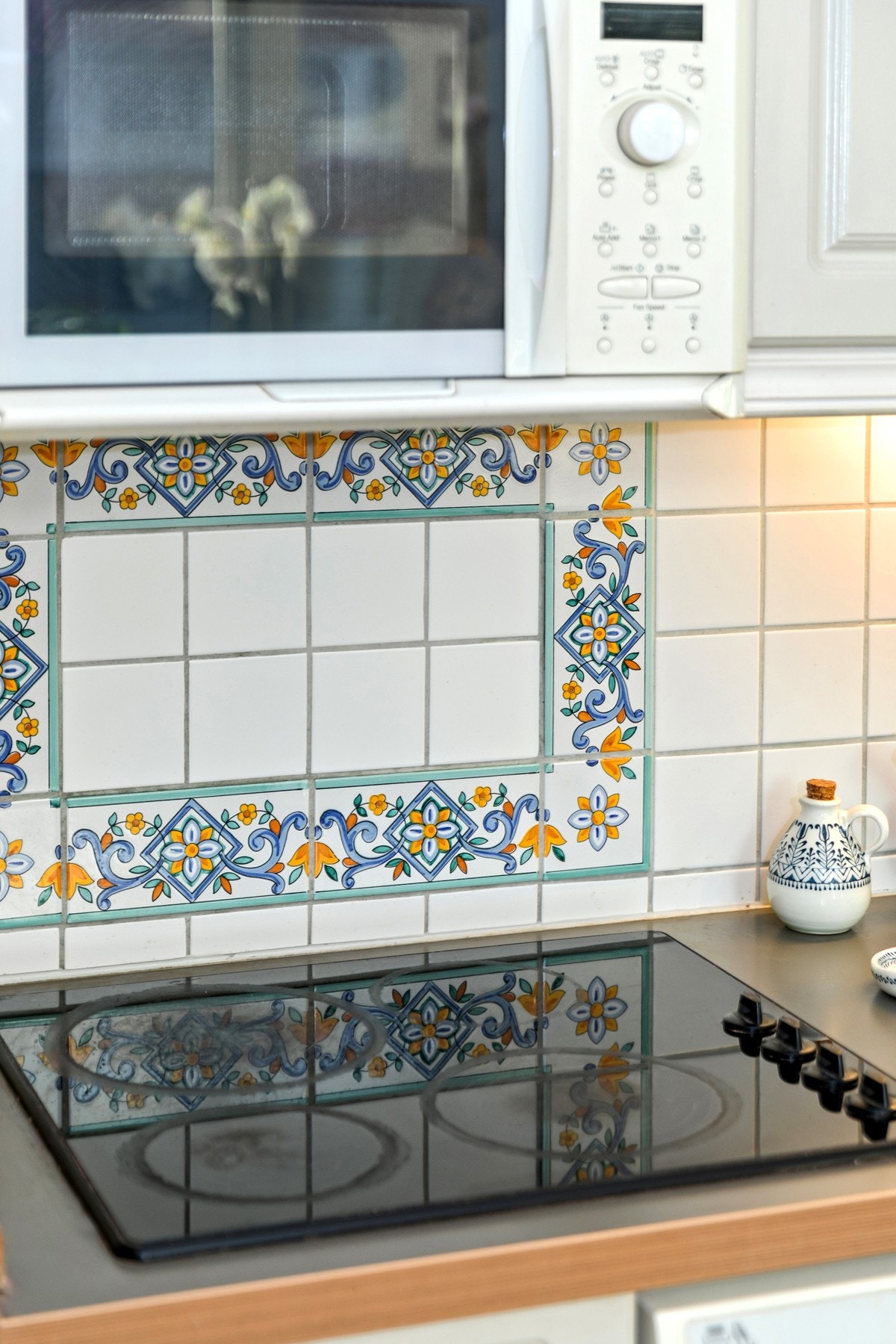 Keramisk koketopp og fliser på vegg over benkeplate Galleribilde