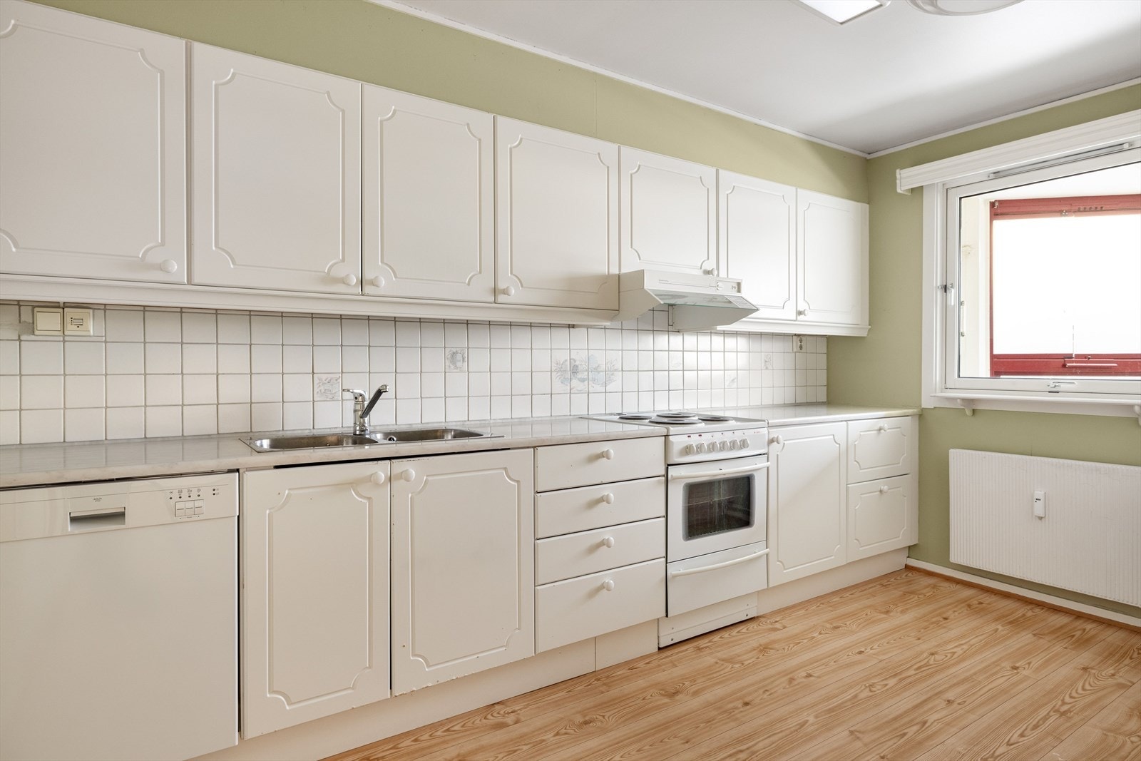 Kjøkken med innredning med hvite, profilerte fronter. Galleribilde