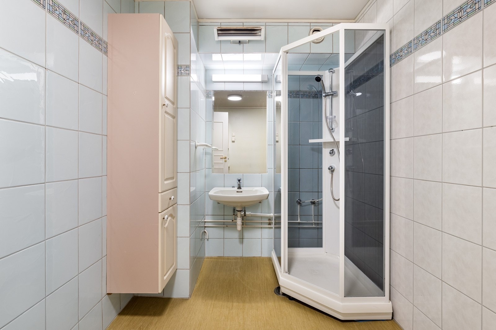 Badet er av eldre dato og det er påregnelig med oppussing. Det er utstyrt med dusjkabinett og håndvask. Galleribilde