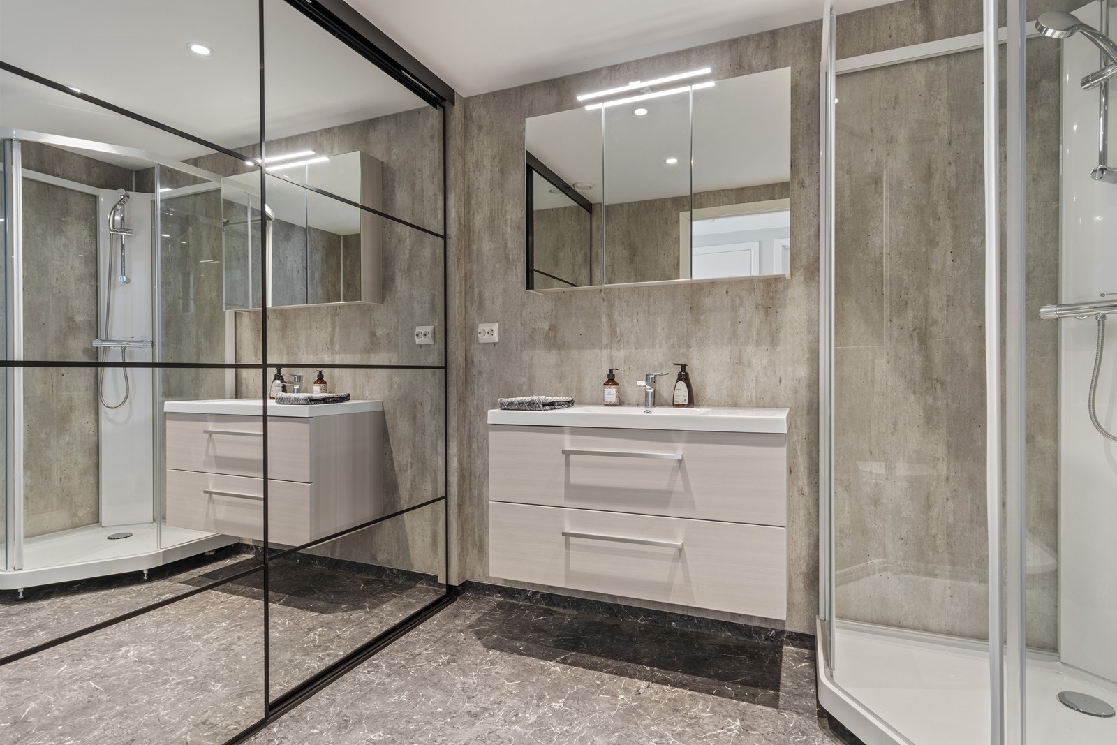 Moderne bad med opplegg til både vaskemaskin og tørketrommel bak skyvedør. Galleribilde