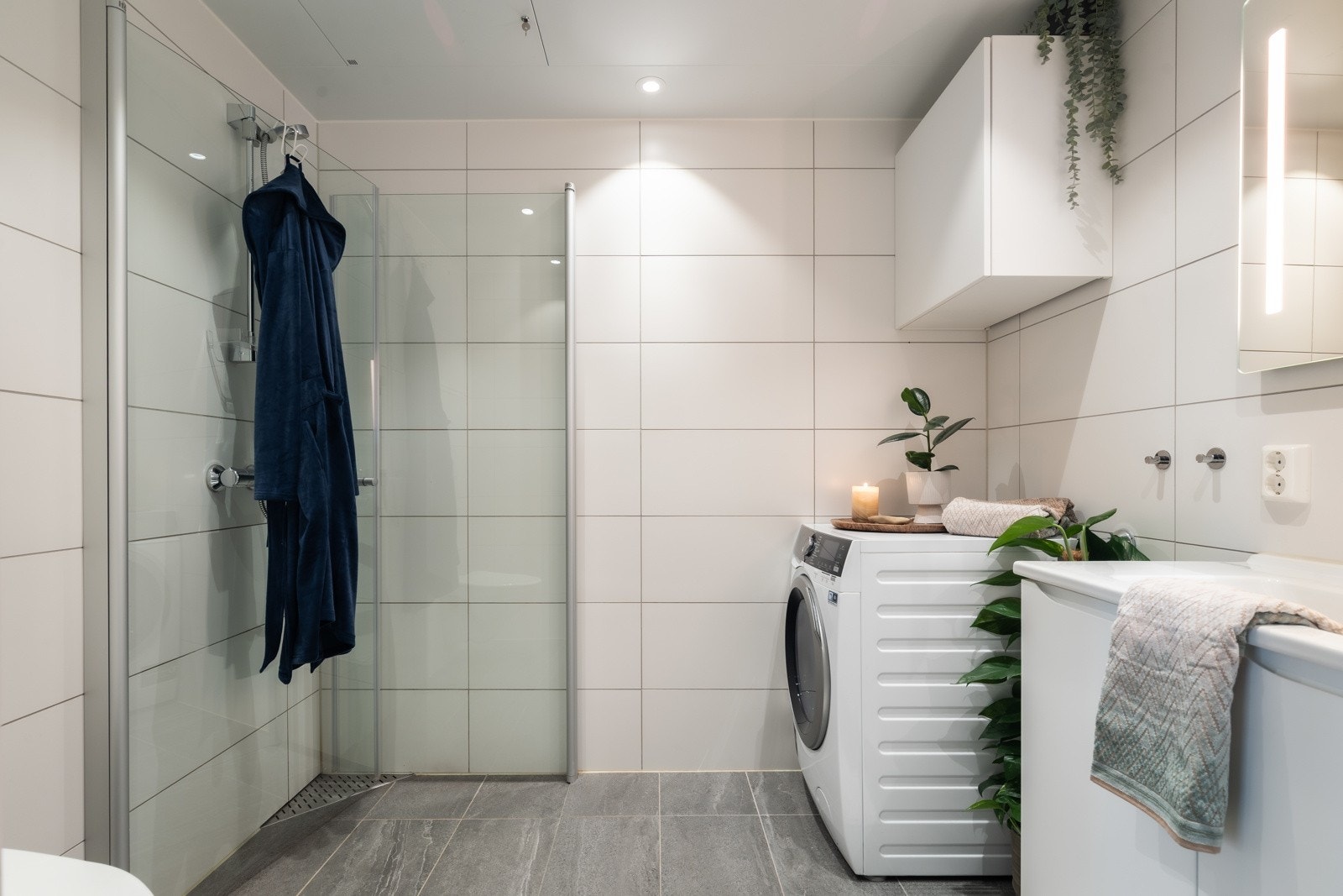 Badet på 4 kvm er flislagt på gulv og vegger, og har flott belysning med downlights i taket og sminkelys integrert i speilet. Galleribilde