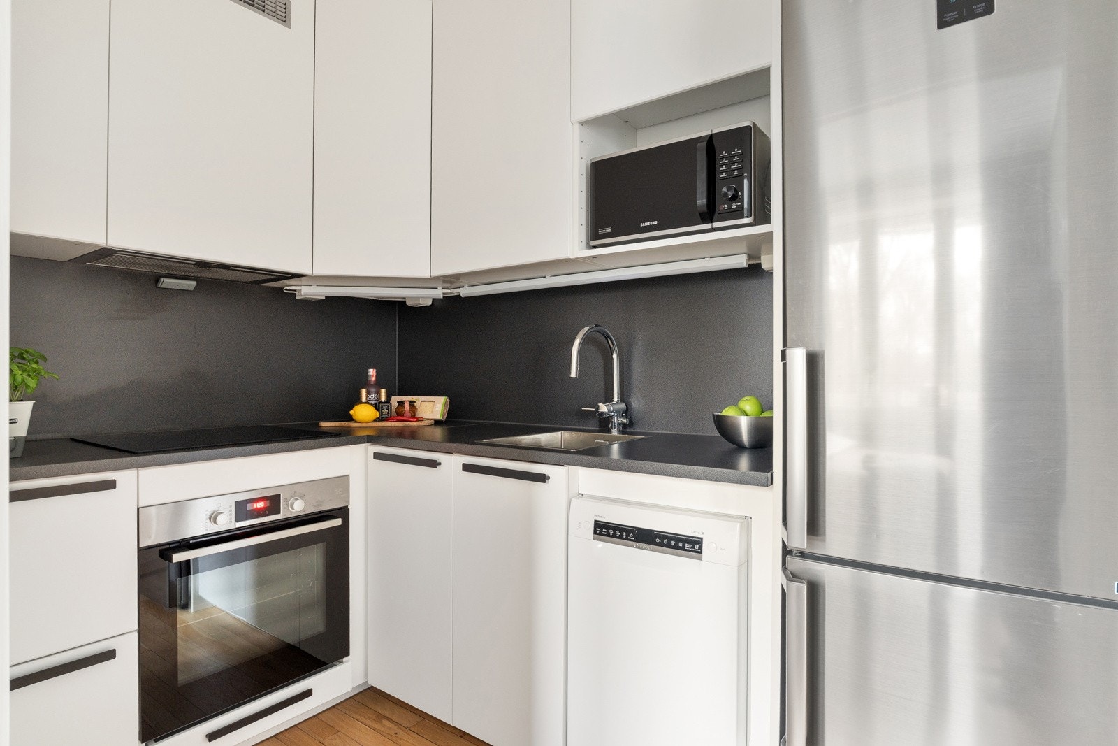 Kjøkken fra 2021 med lyse fronter og diverse integrerte hvitevarer Galleribilde