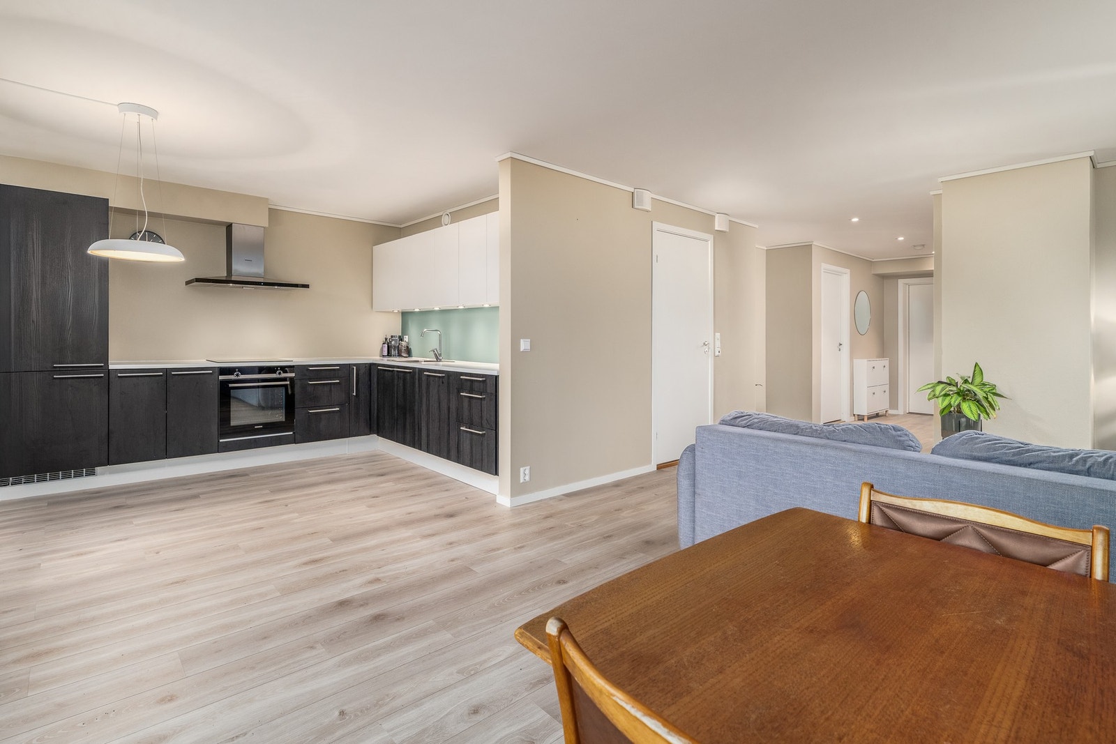 Stue og kjøkken i åpen løsning gjør matlagingen til en sosial aktivitet. Galleribilde