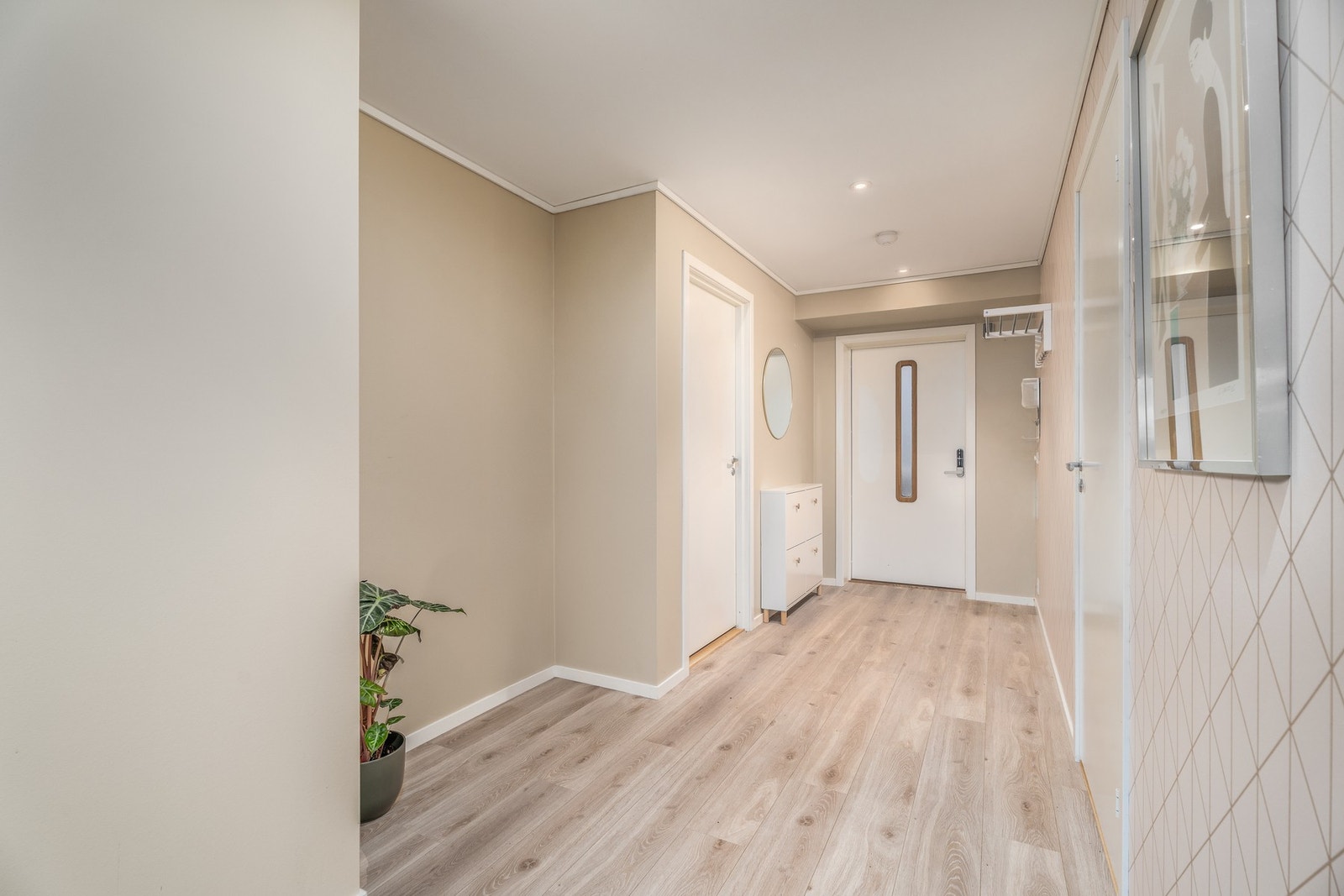 En romslig gang ønsker deg velkommen. Her slipper du å tenke på nøkler med elektrisk kodelås, og om ønskelig er det mulig å sette opp en skyvedørsgarderobe. Galleribilde