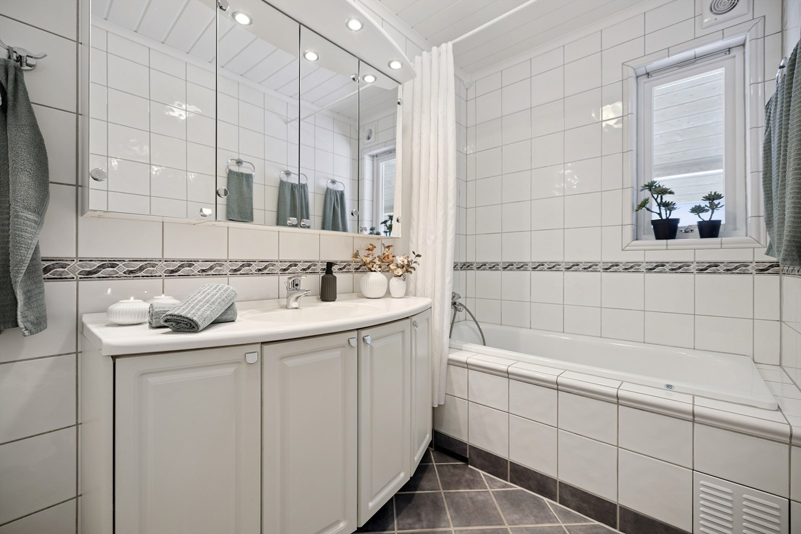 Flislagt bad med gulvvarme og servantinnredning. Galleribilde