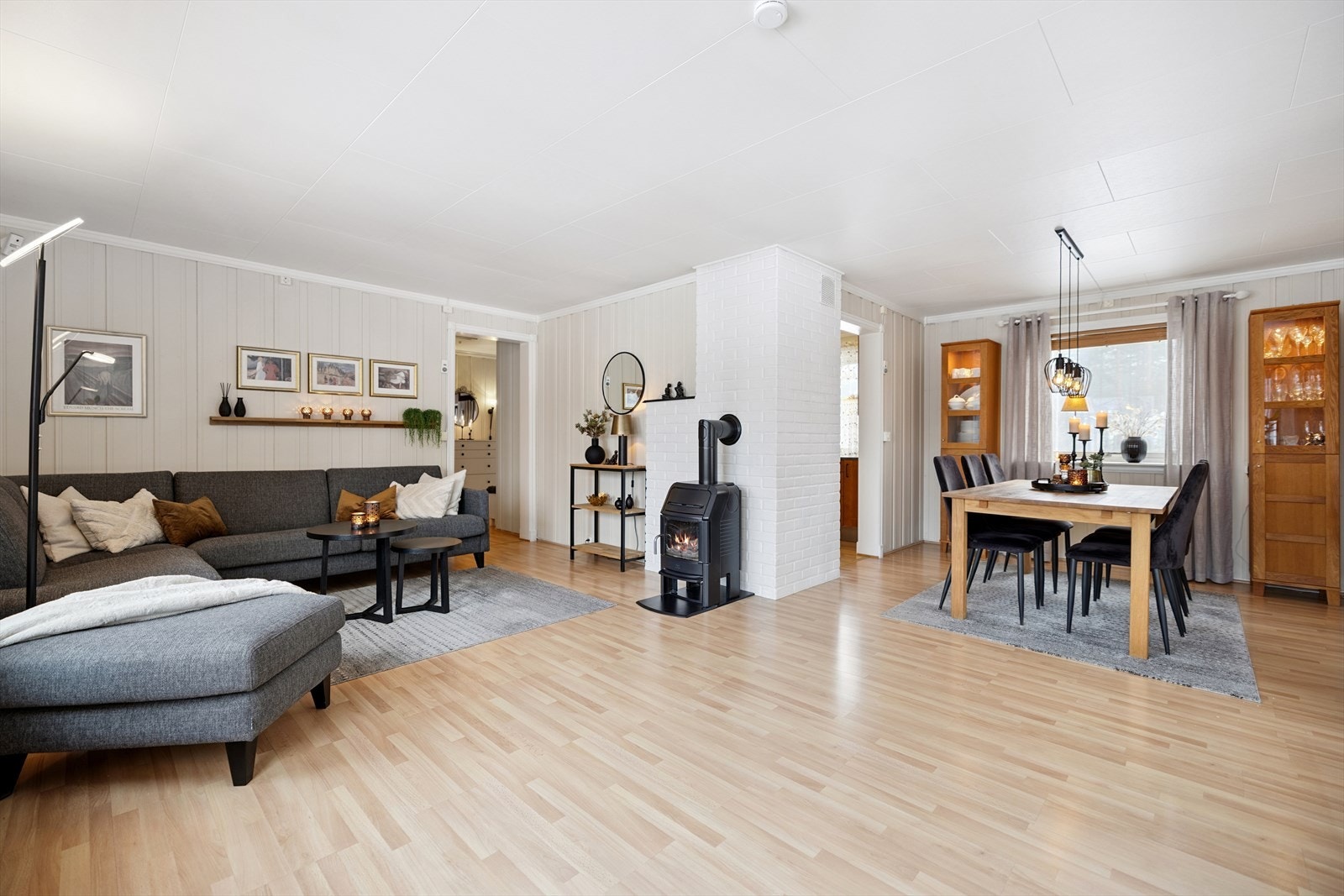 Lys stue med store vindusflater og vedovn. Galleribilde