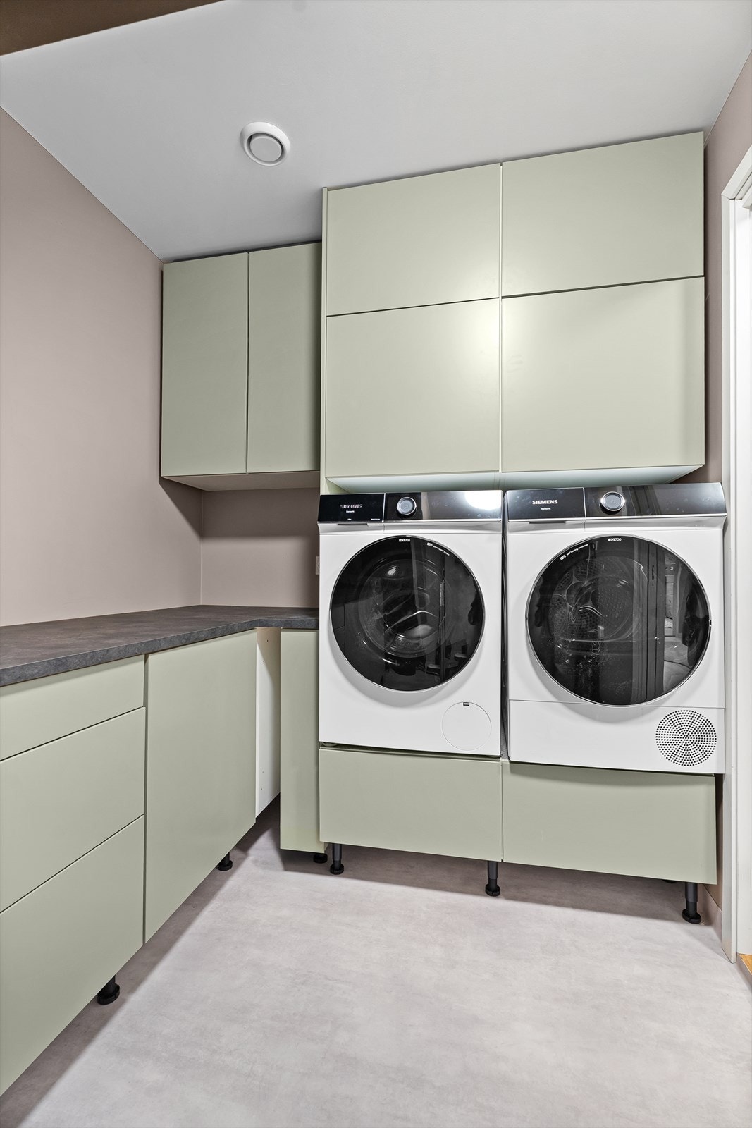 Videre i samme etasje finner vi et innholdsrikt og praktisk vaskerom med god skap- og benkeplass samt opplegg til både vaskemaskin og tørketrommel. Galleribilde