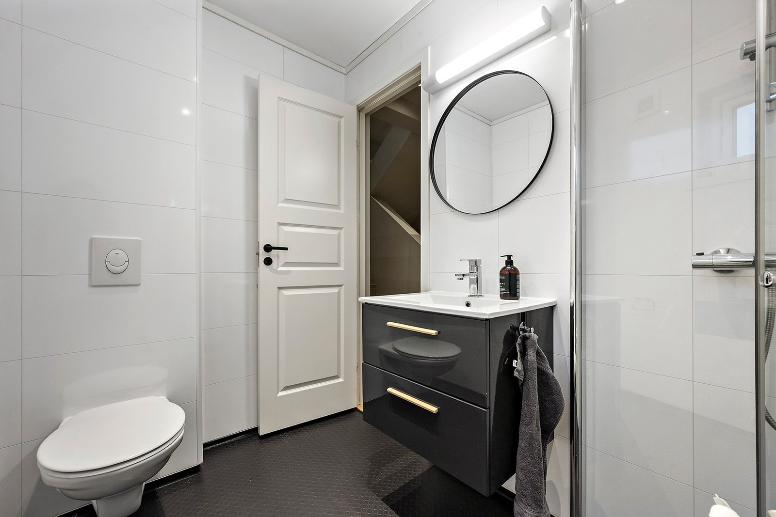 Badet i mellometasjen er innredet med veggfestet WC, innfellbare dusjvegger og baderomsinnredning med servant. Galleribilde