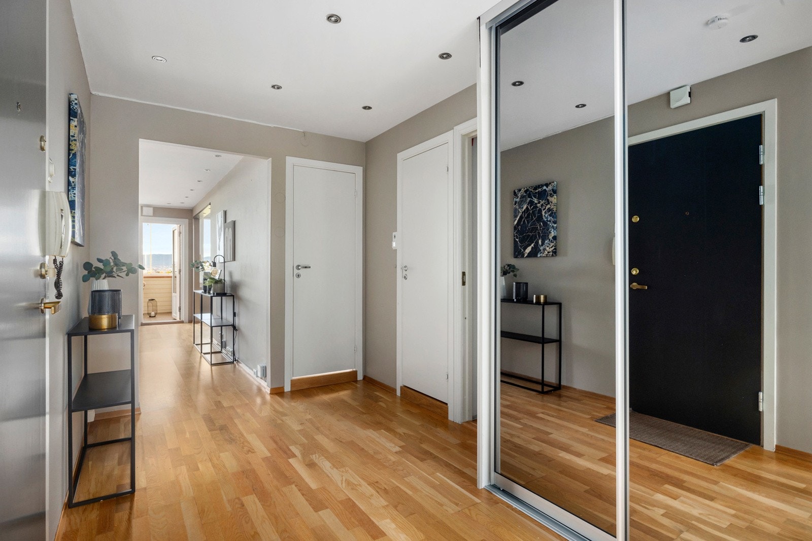 Romslig entré med skyvedørsgarderobe og god plass til oppbevaring av yttertøy og sko. Galleribilde