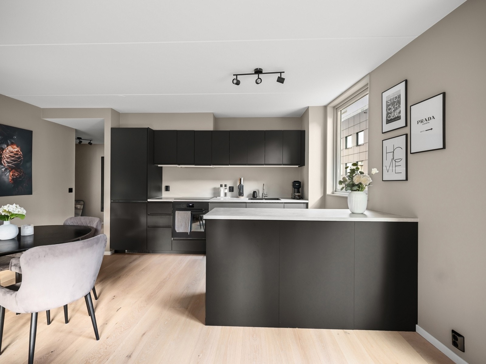 Kjøkkenet har en moderne og gjennomført utforming i en åpen løsning mot stuen. Kjøkkenøya fungerer som et naturlig skille mellom sonene og gir samtidig god plass til oppbevaring. Galleribilde