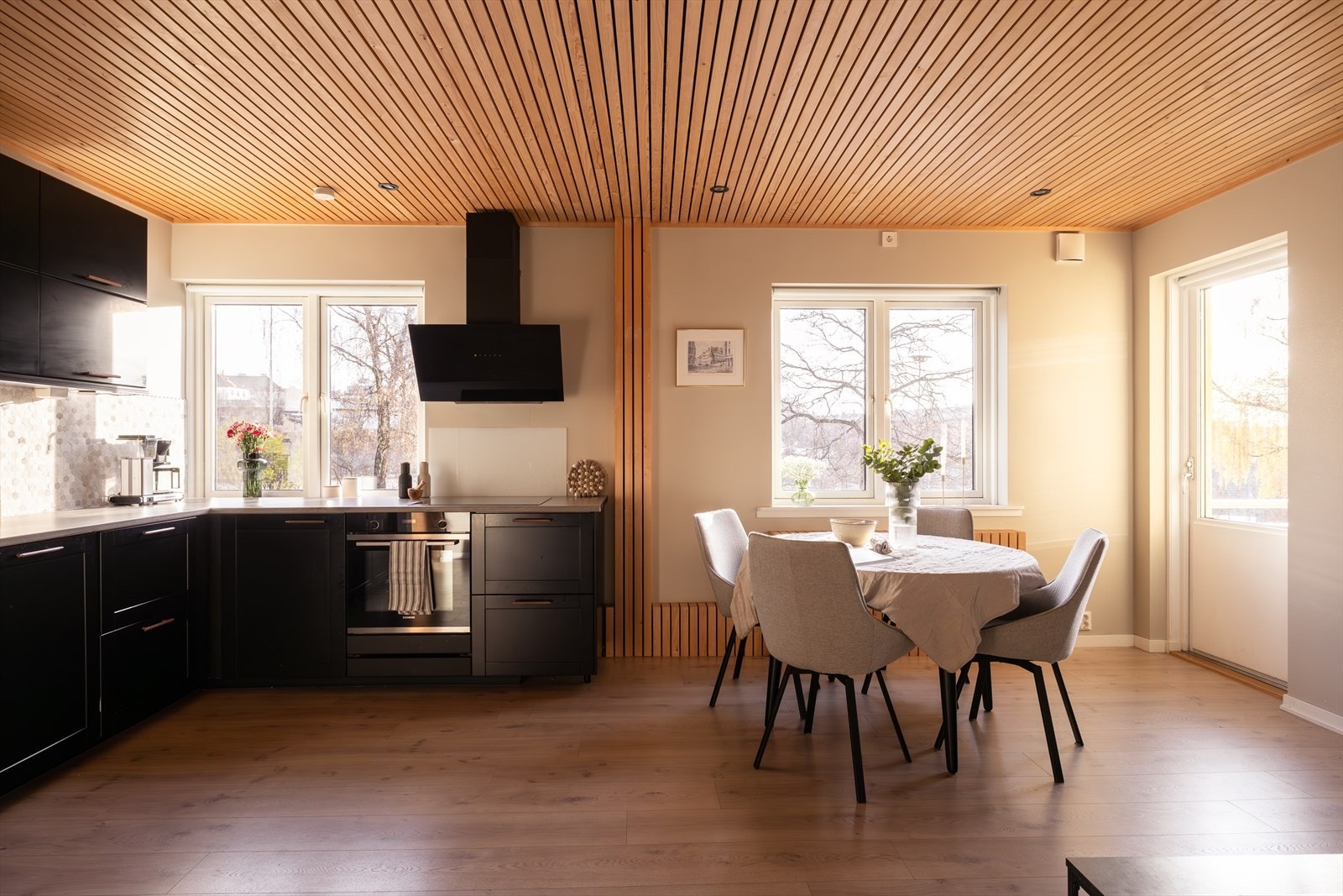 Stilrent sort kjøkken som glir sømløst inn i oppholdsrommet. Galleribilde