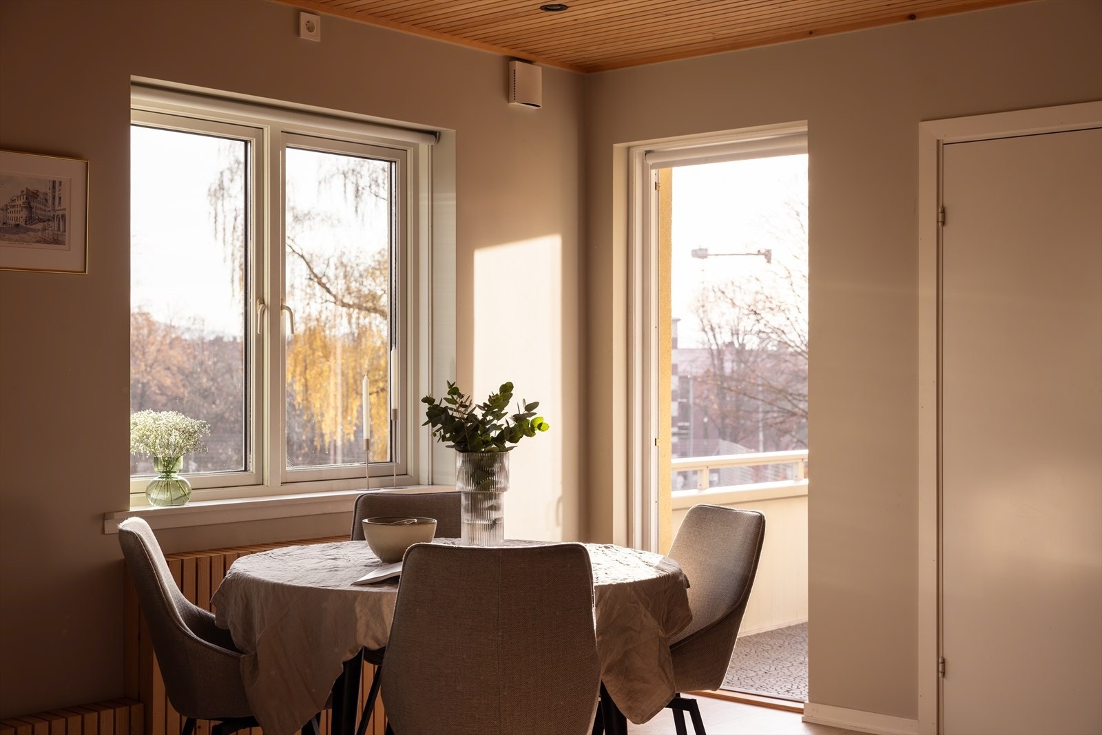 Lys spisekrok med vinduer mot balkongen og grøntområdet. Galleribilde