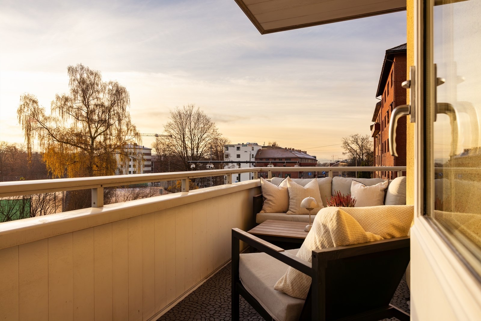 Solrik balkong med sittegruppe og utsikt mot tennisbanene. Galleribilde