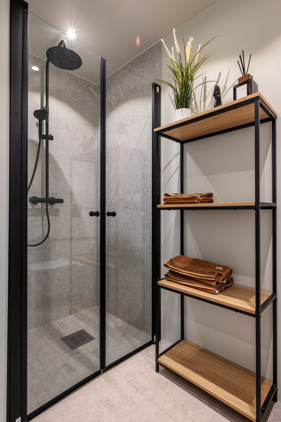 Dusjhjørnet er utstyrt med sort regnfallsdusj og innfellbare glassdører i sort innramming. Galleribilde