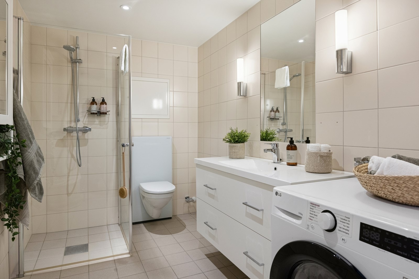 Dusjhjørne, vegghengt toalett, bred servant med underskap og opplegg for vaskemaskin. Varmtvann kommer via fjernvarme. Galleribilde