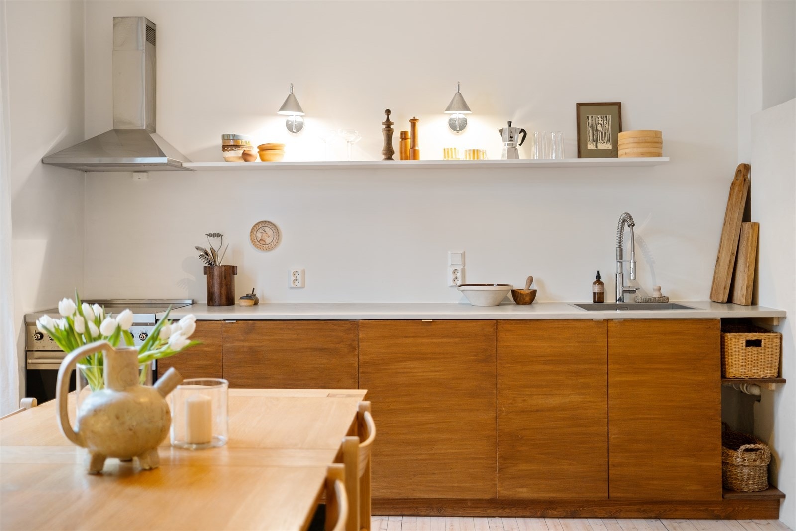 Kjøkkeninnredning med oljede trefronter og benkeplate av stein med nedfelt vask. Galleribilde