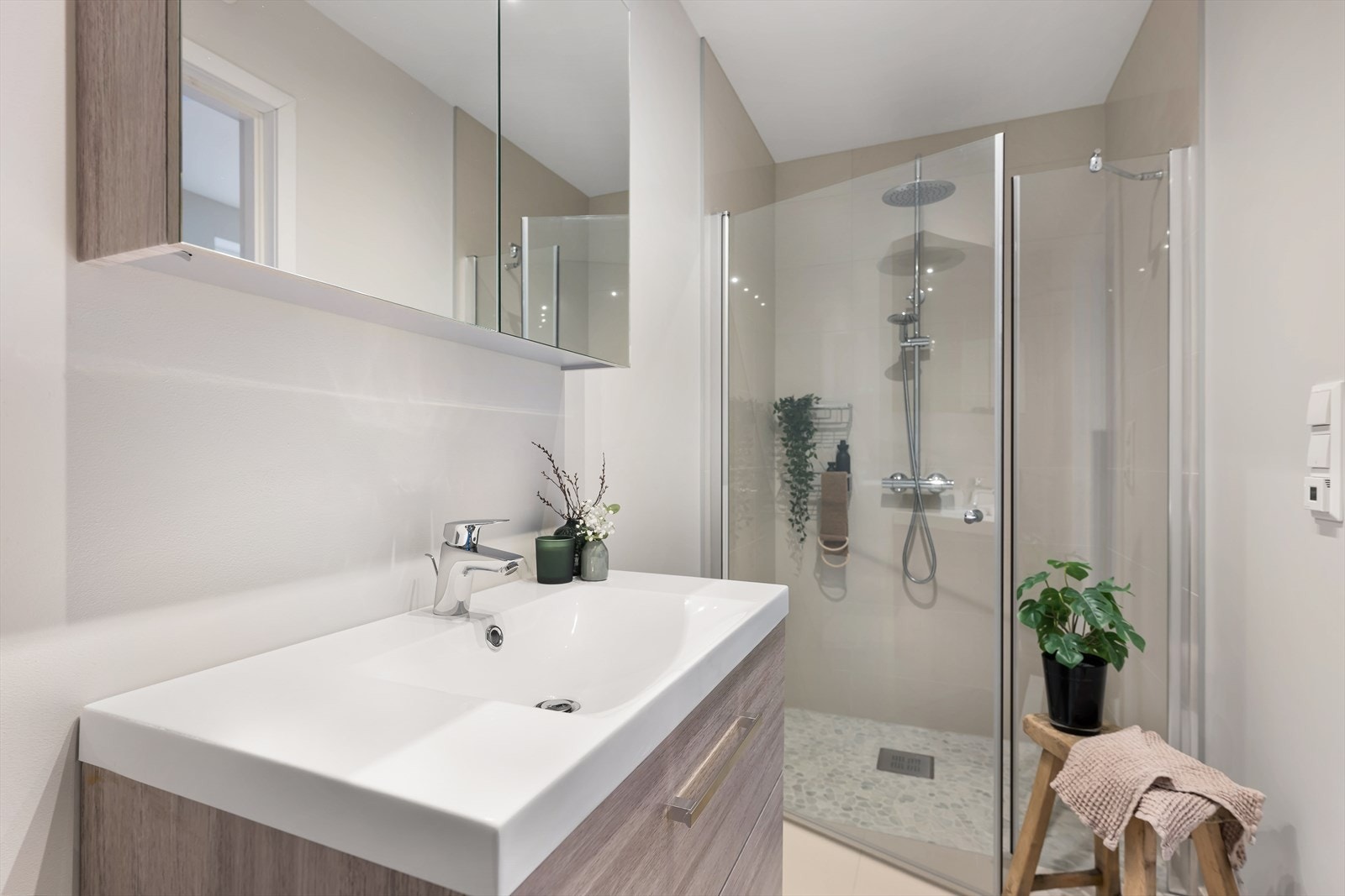 Baderom fra 2021. Meget stor og god dusjsone, moderne møbler og fliser i lun og moderne fargetoner. Galleribilde