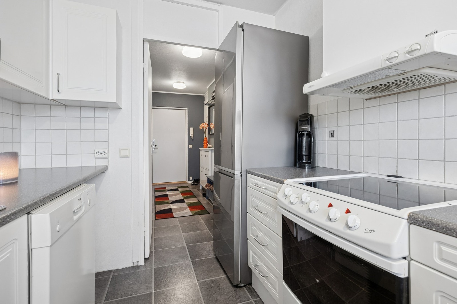 Kjøkkenet er utstyrt med frittstående komfyr, oppvaskmaskin, kjøleskap med fryser samt vaskemaskin, noe som gir en effektiv og plassbesparende løsning. Galleribilde