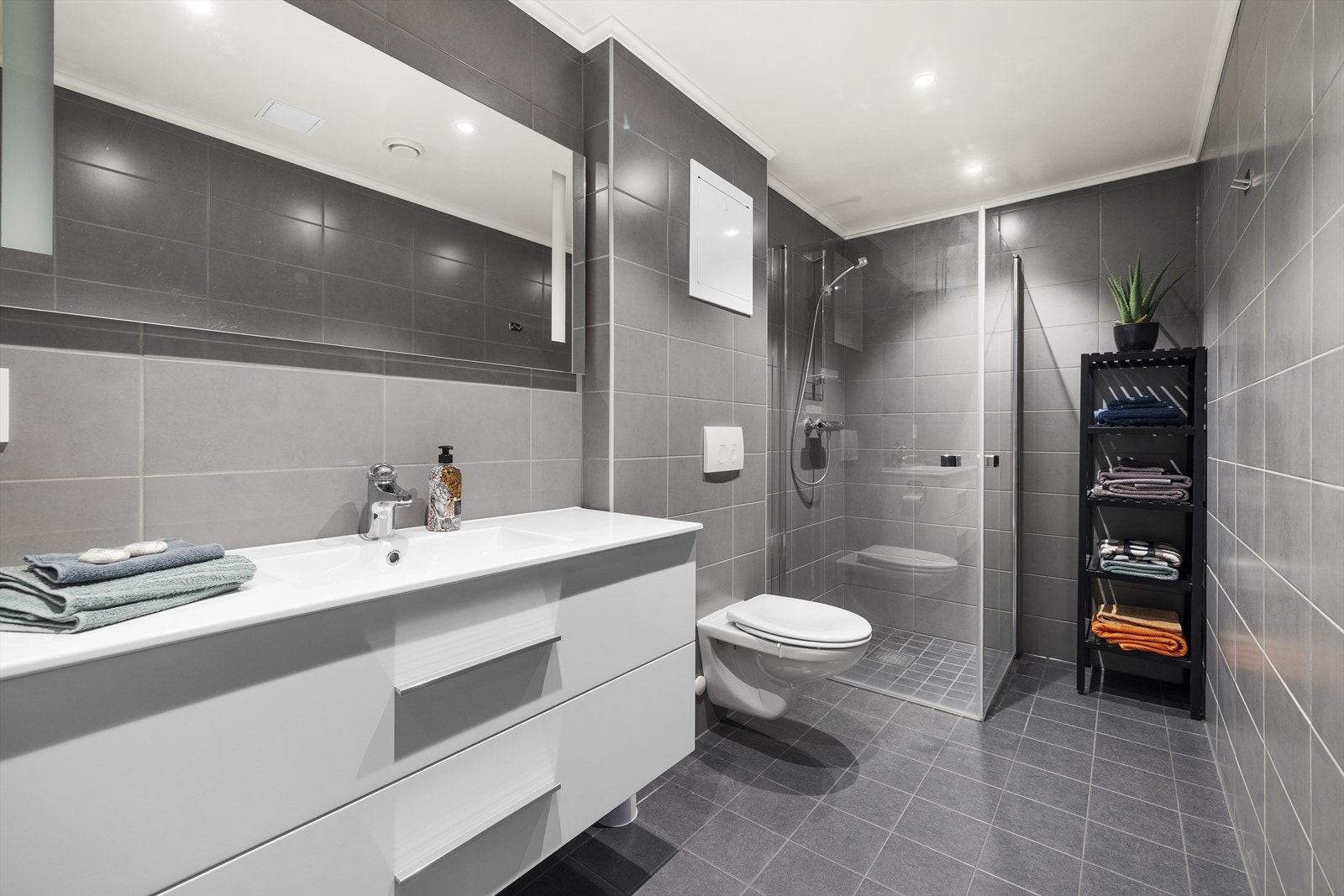 Lekkert og stort baderom, med flislagte vegger og gulv, med varmekabler - oppusset i regi av borettslaget i 2025 Galleribilde