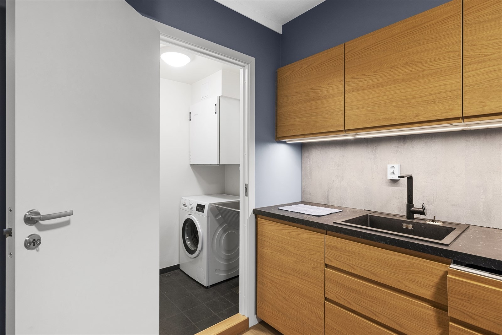 Fra kjøkken er det inngang til separat vaskerom Galleribilde