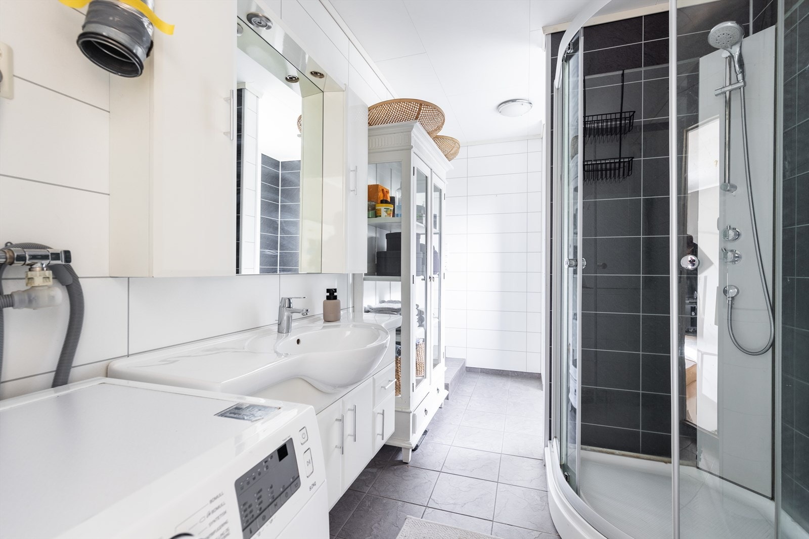 Badet er innredet med nedfelt servant, servant, toalett, dusjkabinett, opplegg og plass for vaskemaskin og varmtvannstank. Galleribilde