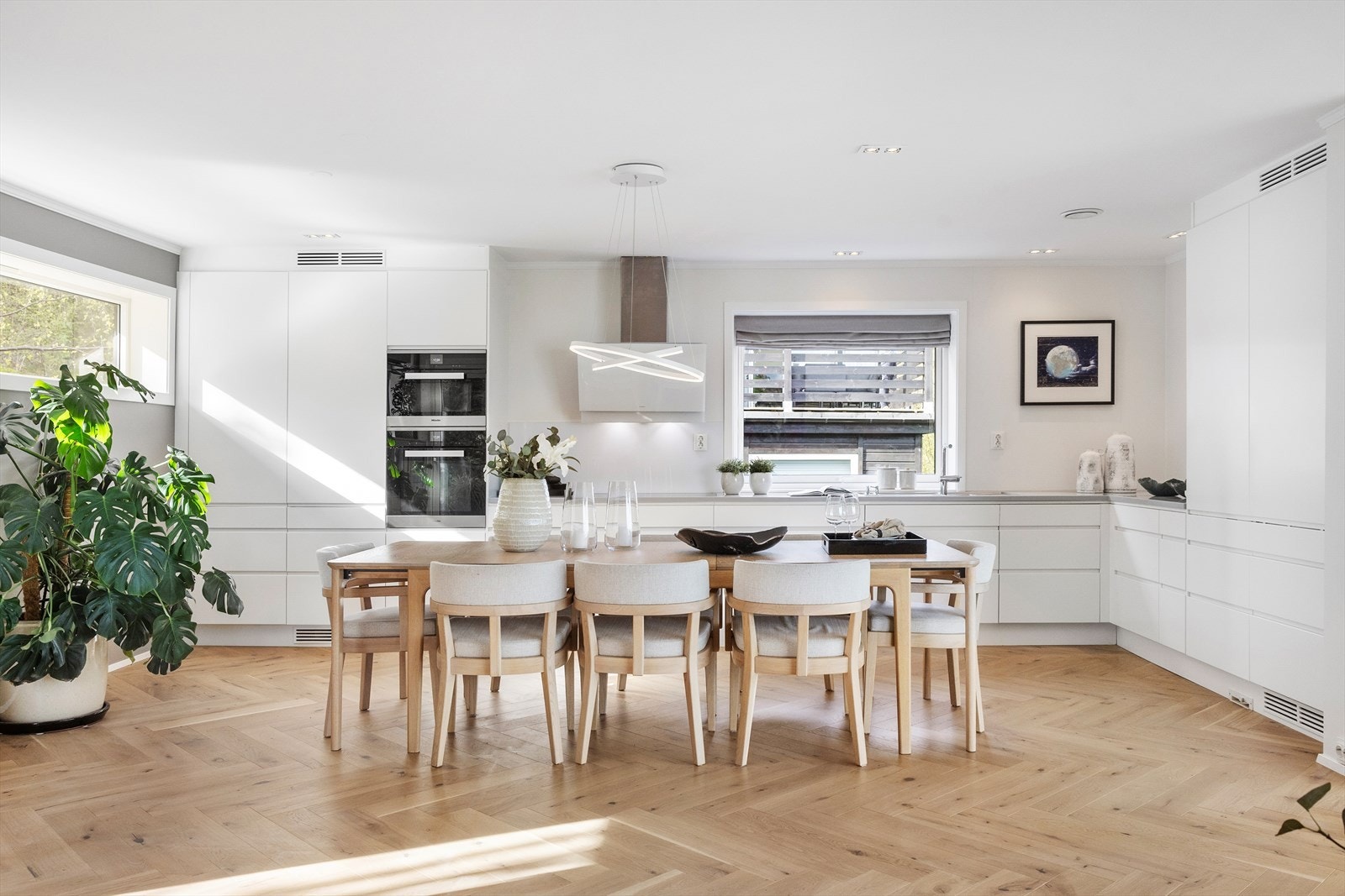 Kjøkkeninnredning fra Drømmekjøkkenet (2014) med hvite glatte fronter og benkeplate av Corian. Det er underlimt oppvaskkum av rustfritt stål med ett-greps armatur. Galleribilde