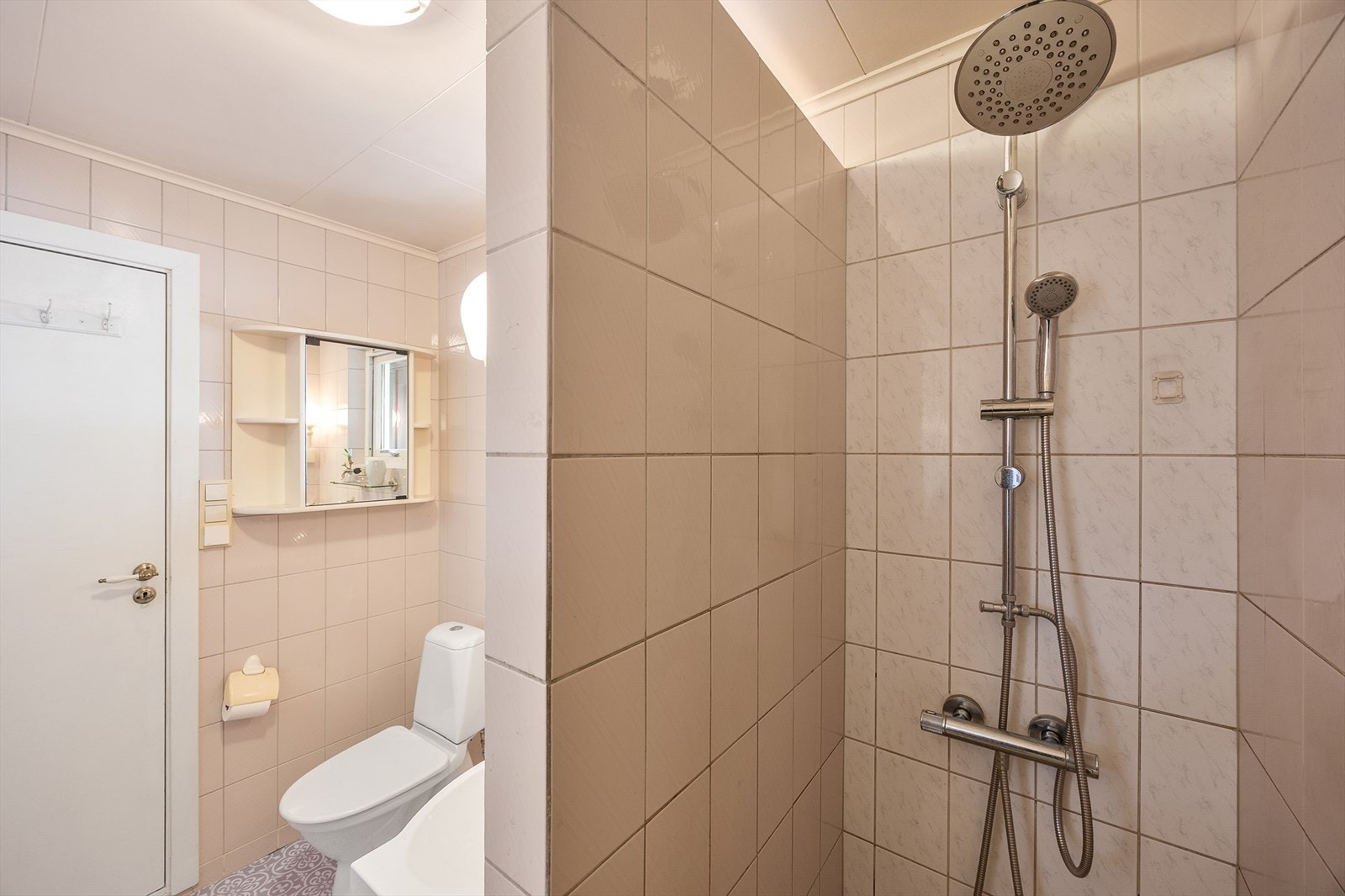 Toalettet er gulvmontert og badet har åpen dusjnisje med både hånd- og regnfallsdusj. Galleribilde