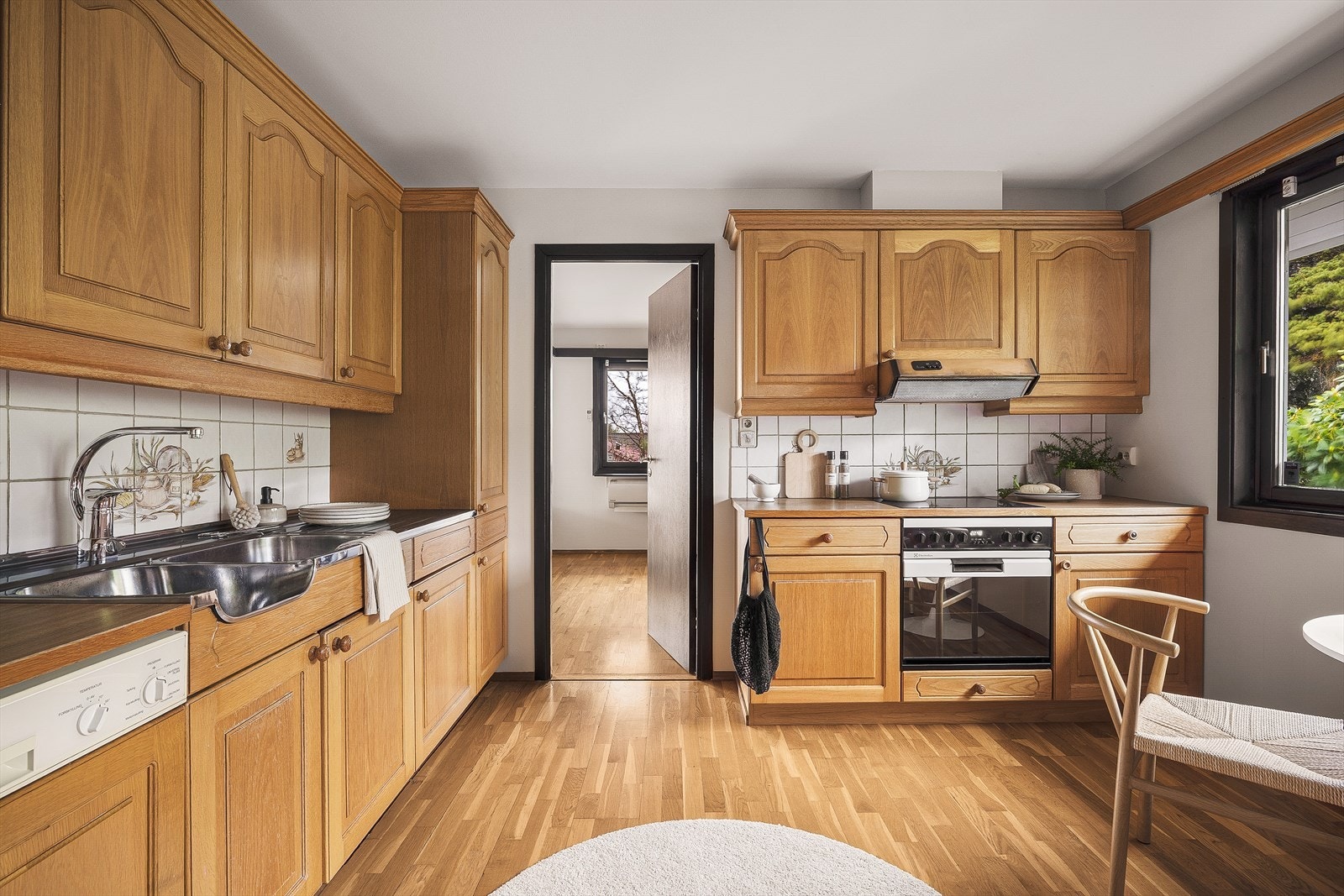 Lyst og romslig kjøkken med klassiske treinnredninger og store vinduer som gir rikelig med naturlig lys Galleribilde