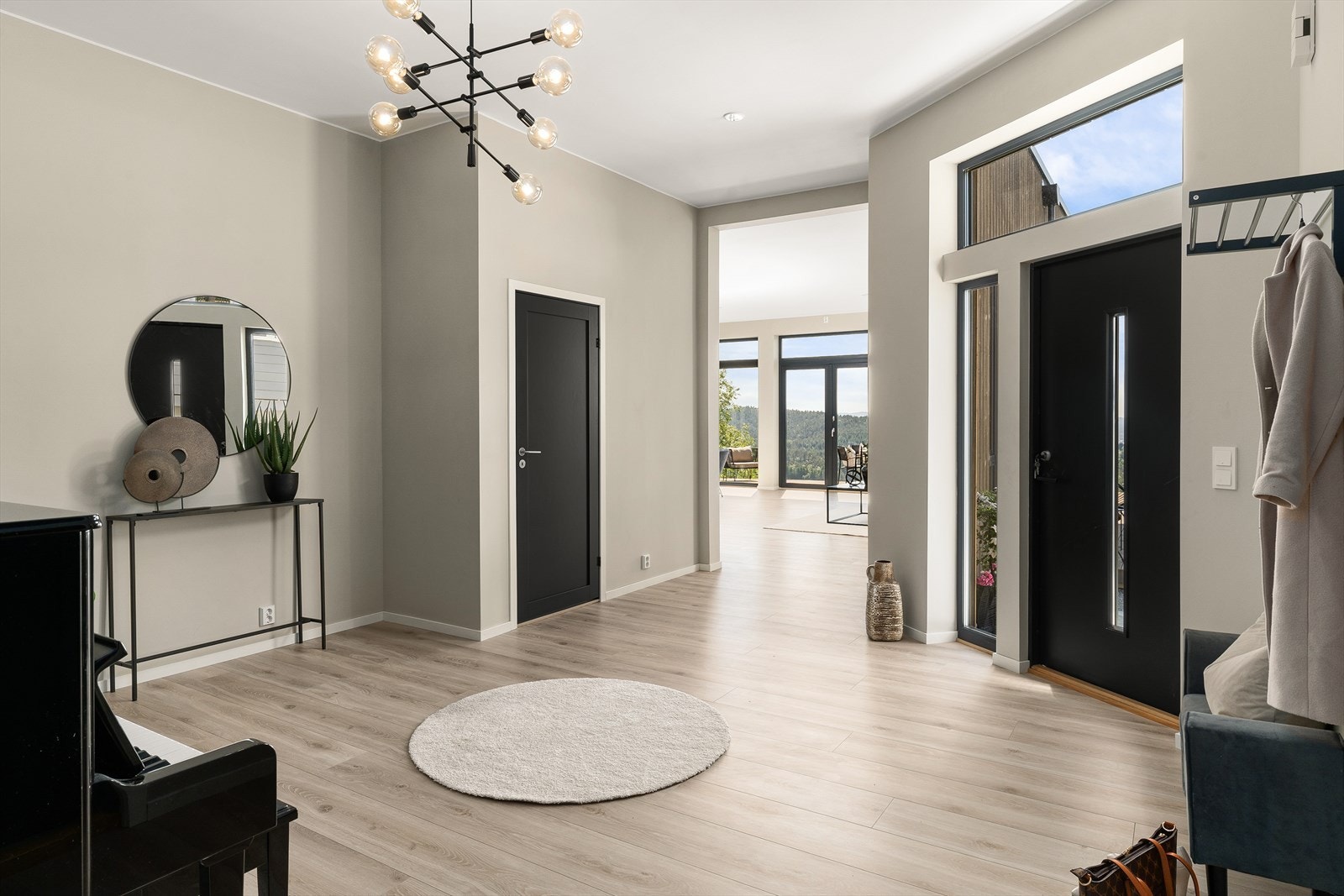 Lys og innbydende gang/entrè med moderne detaljer og store vinduer som slipper inn rikelig med naturlig lys. Galleribilde