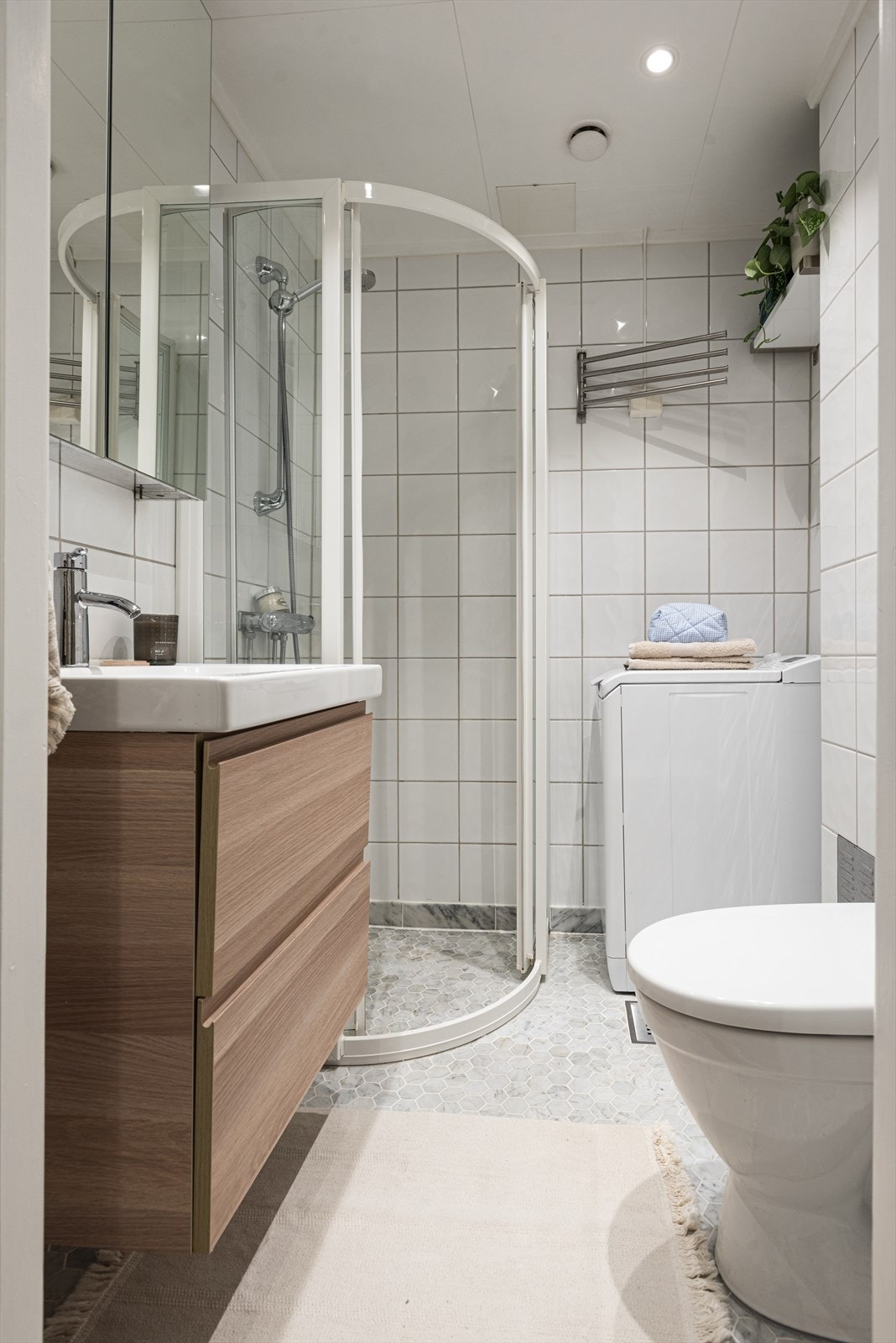 Dusjhjørne med glassdører på skinner. Det er opplegg for vaskemaskin. Galleribilde