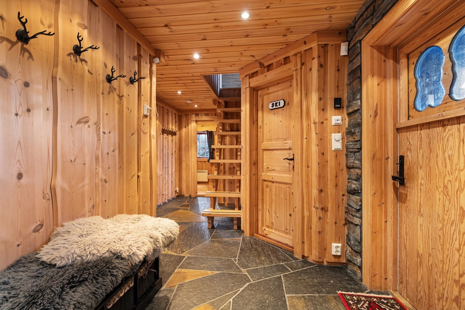 Her ønskes du velkommen inn i hall med gulvvarme som har plass til å henge fra seg ytterklær. Galleribilde
