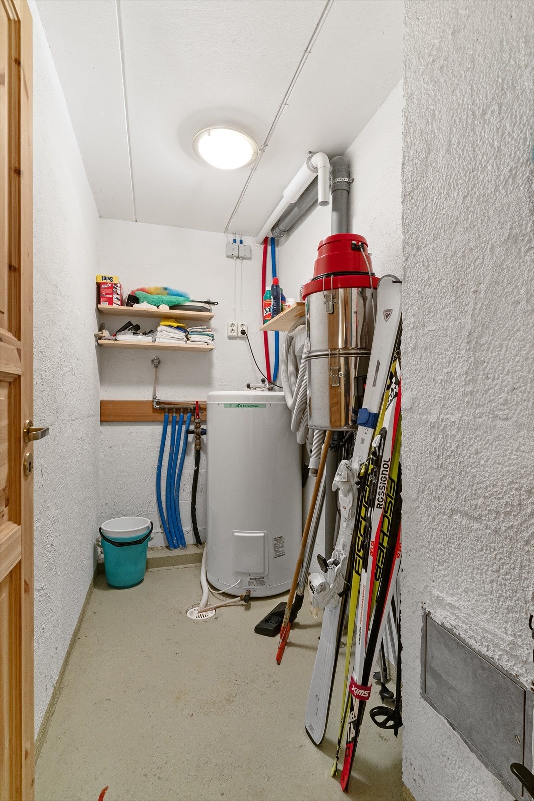 I tillegg har kjelleren et teknisk rom/vaskerom, hvor det er opplegg til vaskemaskin. Her er også varmtvannsbereder plassert, og det er sluk i gulvet. Vannfordelerstokk. Støpt gulv. Feierluke til pipe. Galleribilde