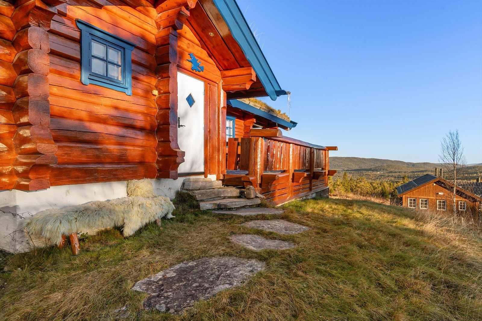 Inngangspartiet er steinlagt med skiferheller og naturlig gressplen. Velkommen inn! Galleribilde