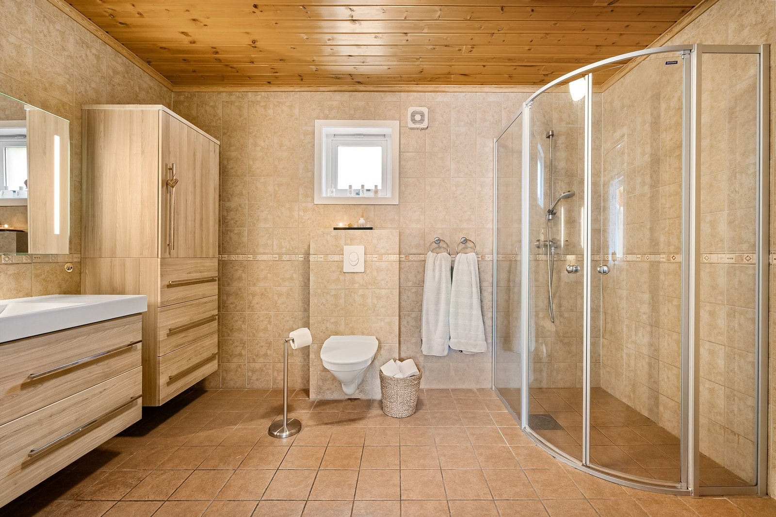 Badet har stor innreiing med god oppbevaringsplass, vegghengt wc og dusj med semiebue Galleribilde