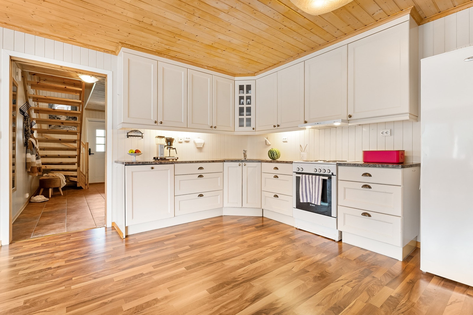 Lyst og pent kjøkken, med profilerte frontar og frittståande kvitevarer. Galleribilde